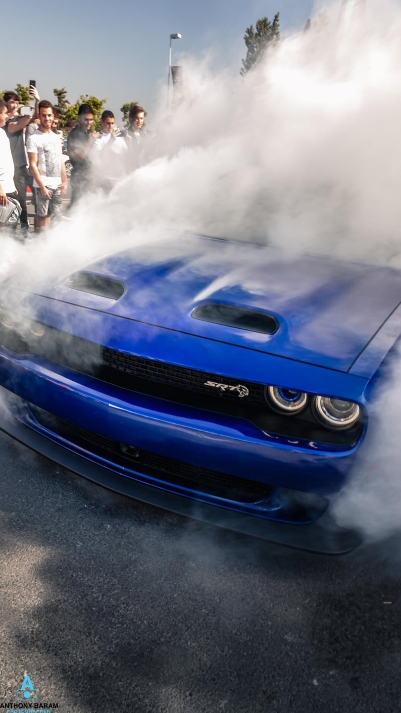 Blue Challenger Hellcat doing a burnout in front of a crowd